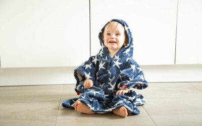 Un bébé au sec avec la serviette de plage avec capuche FRUGI de chez Happy Hippy Baby